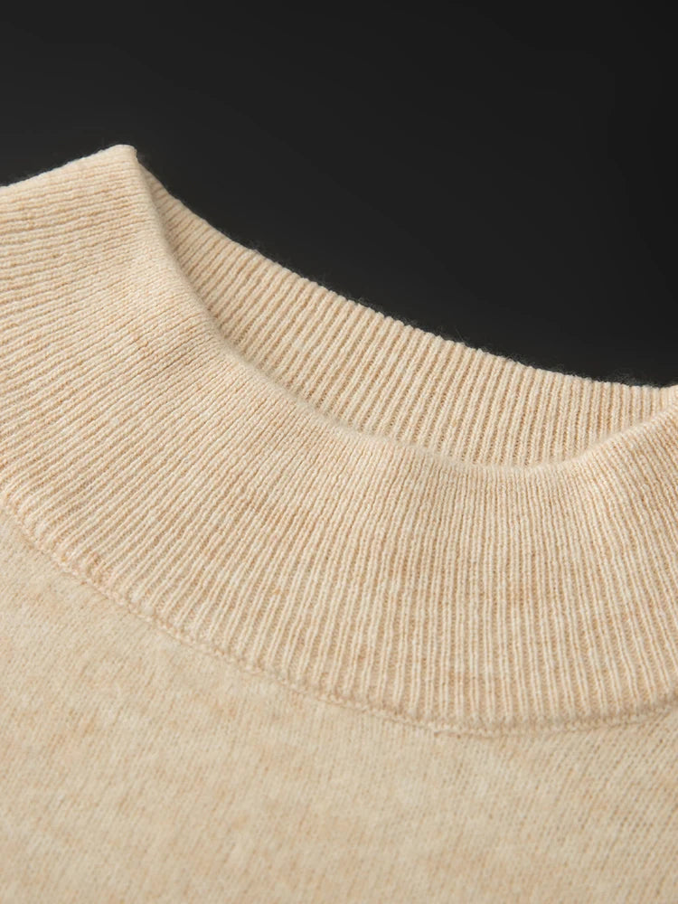 Close-up of a beige sweater collar against a black background