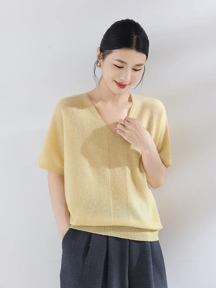 Woman wearing a light yellow sweater against a white background